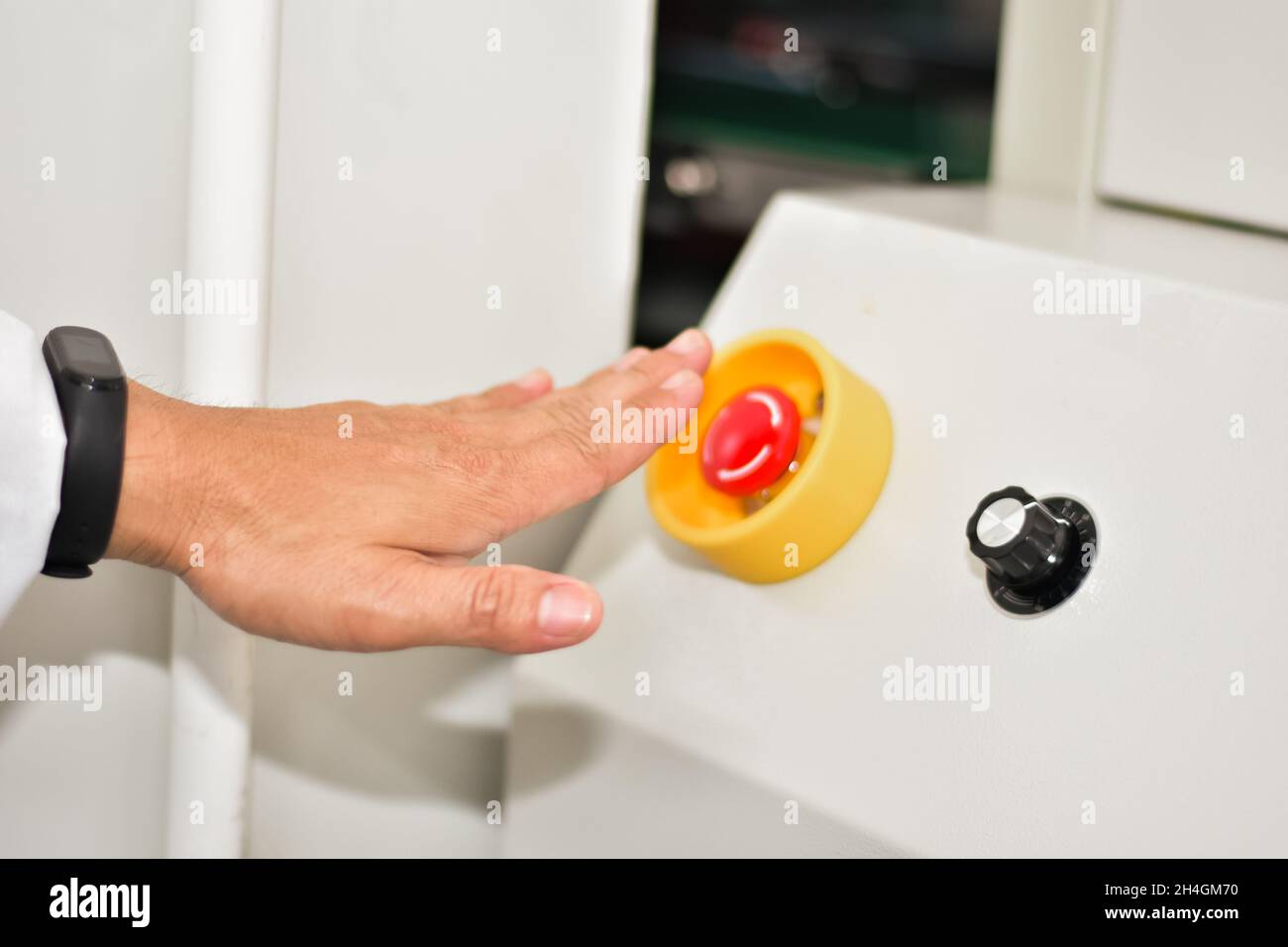 Hand touch on emergency stop machine Stock Photo