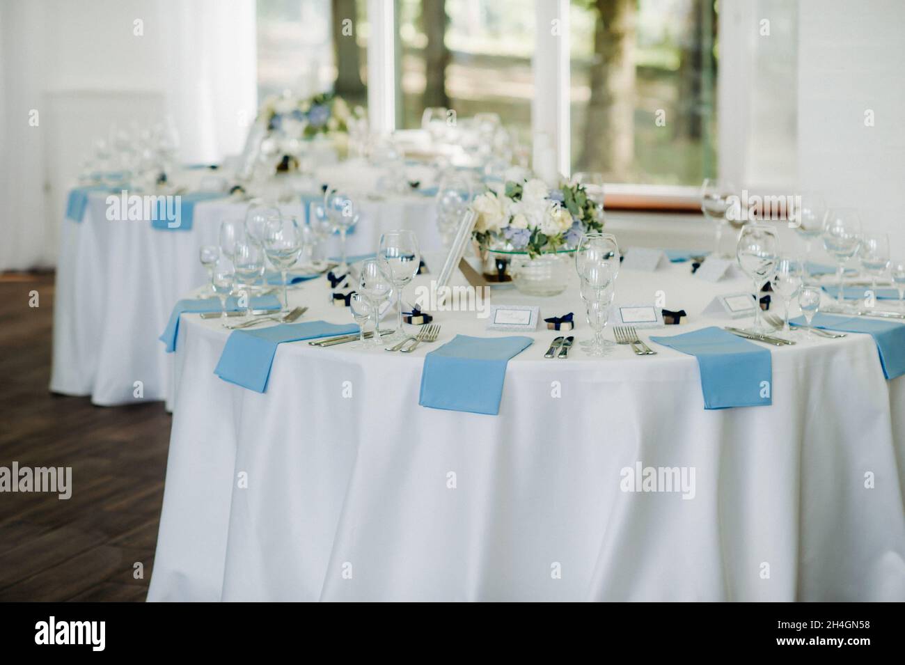 wedding table decoration with blue flowers on the table in the restaurant table  decor for dinner at the wedding Stock Photo - Alamy, image size:1300x955