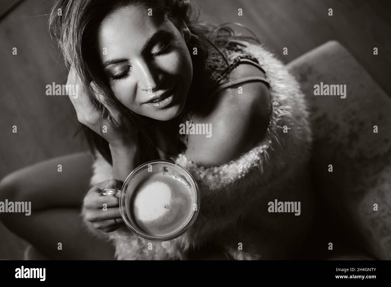 relaxed girl at home drinking coffee.Inner peace.The girl is sitting comfortably on the sofa and drinking coffee.black and white photo Stock Photo