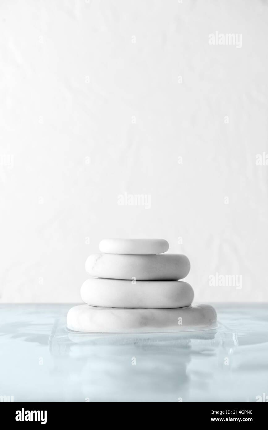 Stack of spa stones in water on white background Stock Photo - Alamy