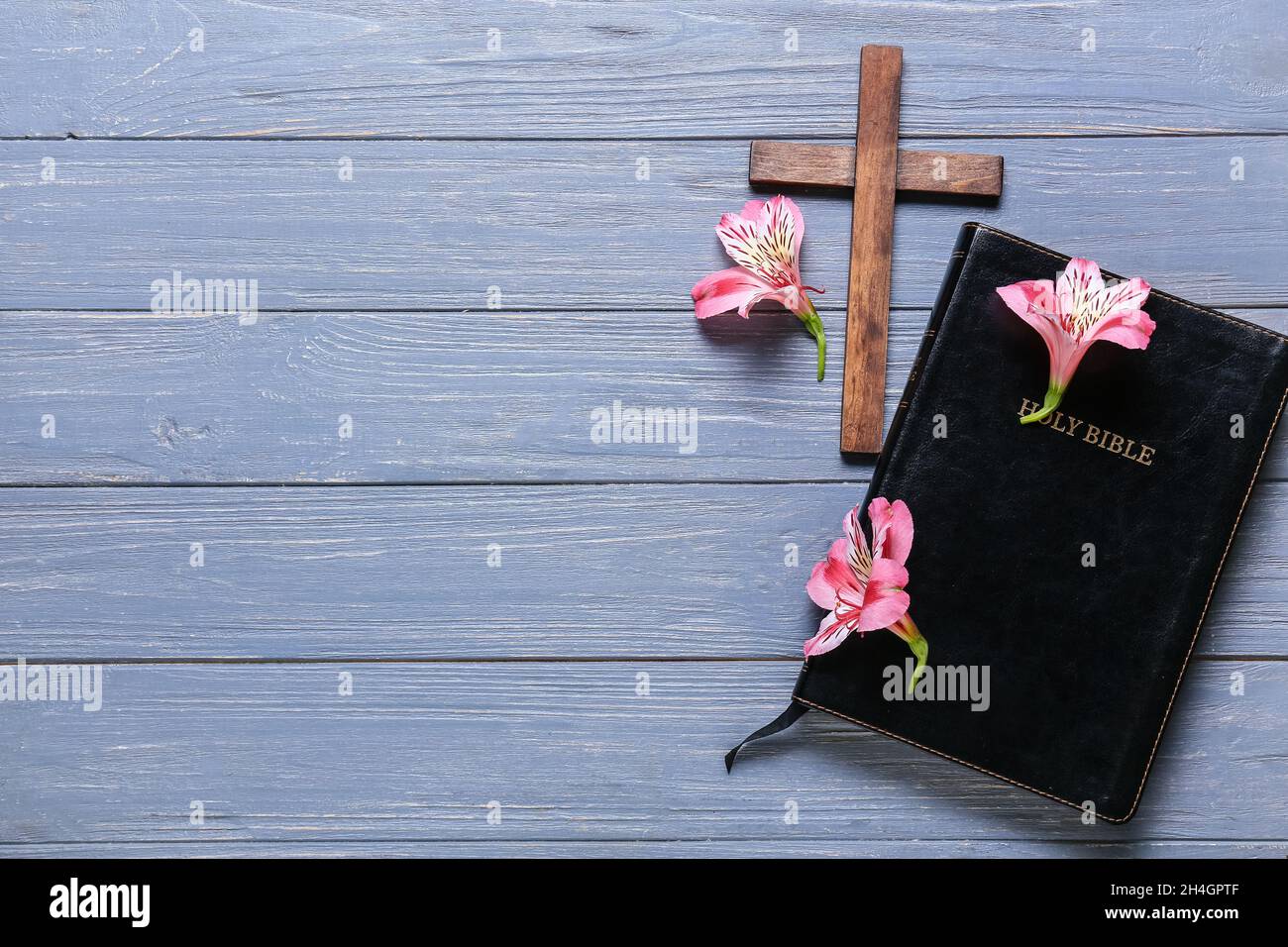 Blue Bible With Flowers Holy Bible with lily flowers and cross on blue wooden background Stock ...