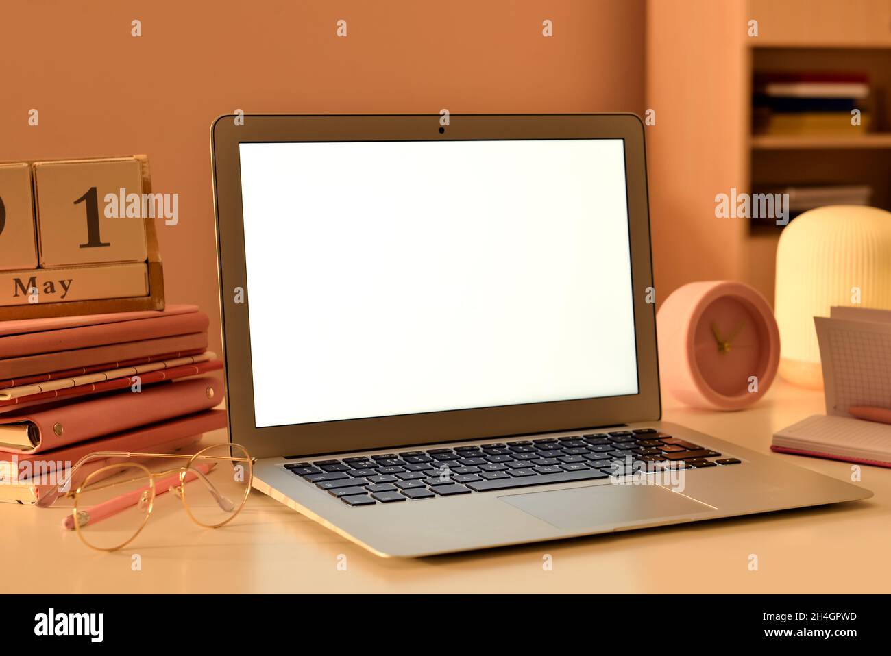 Laptop with blank screen on table in office Stock Photo - Alamy