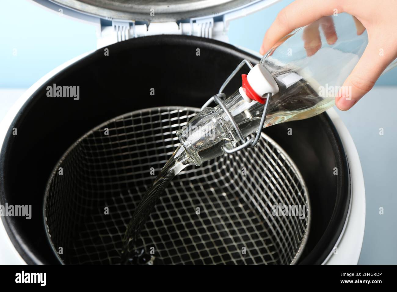 Woman pouring sunflower oil in deep fryer Stock Photo Alamy
