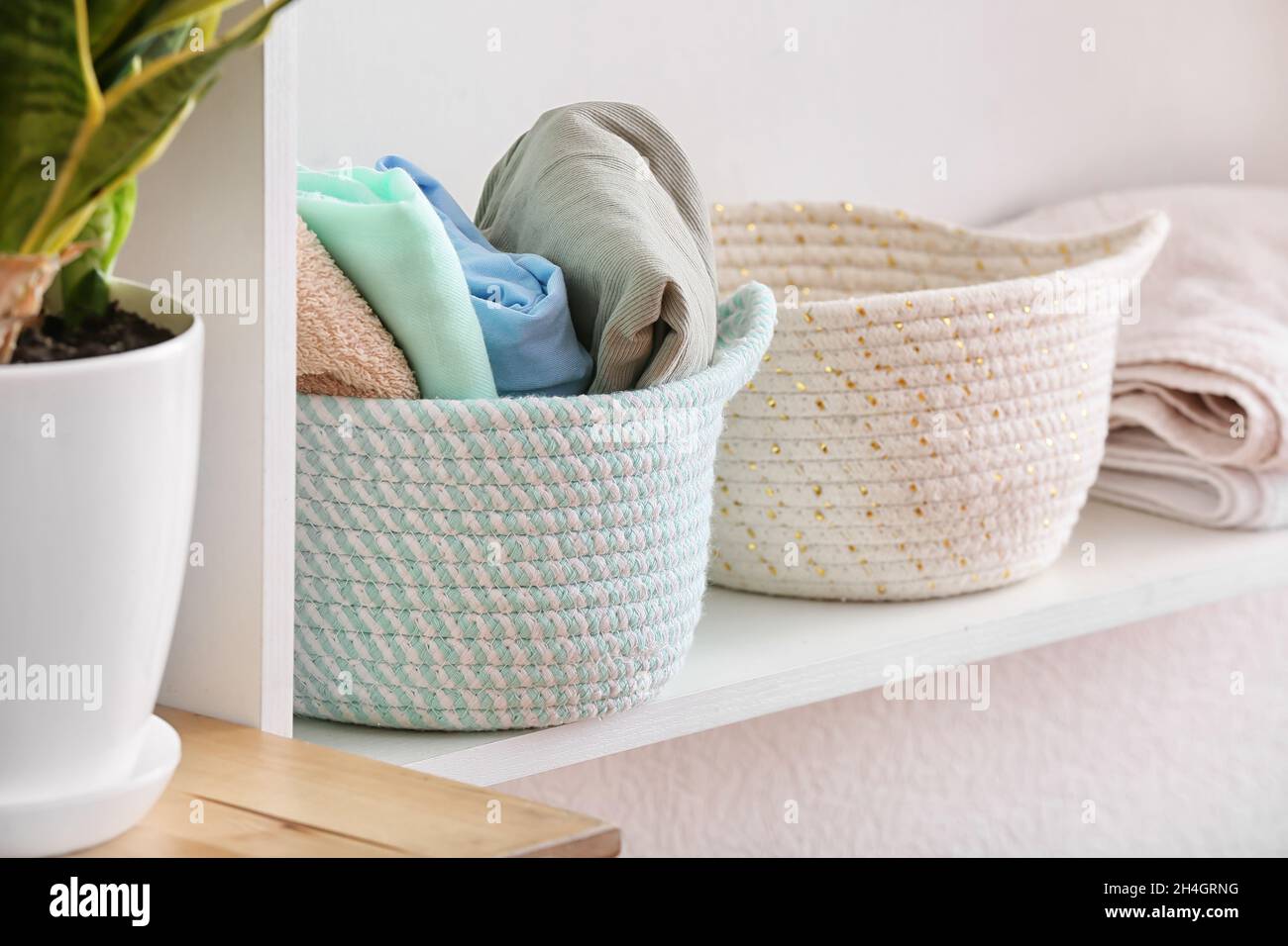 Baskets with clean clothes on shelf, closeup Stock Photo Alamy