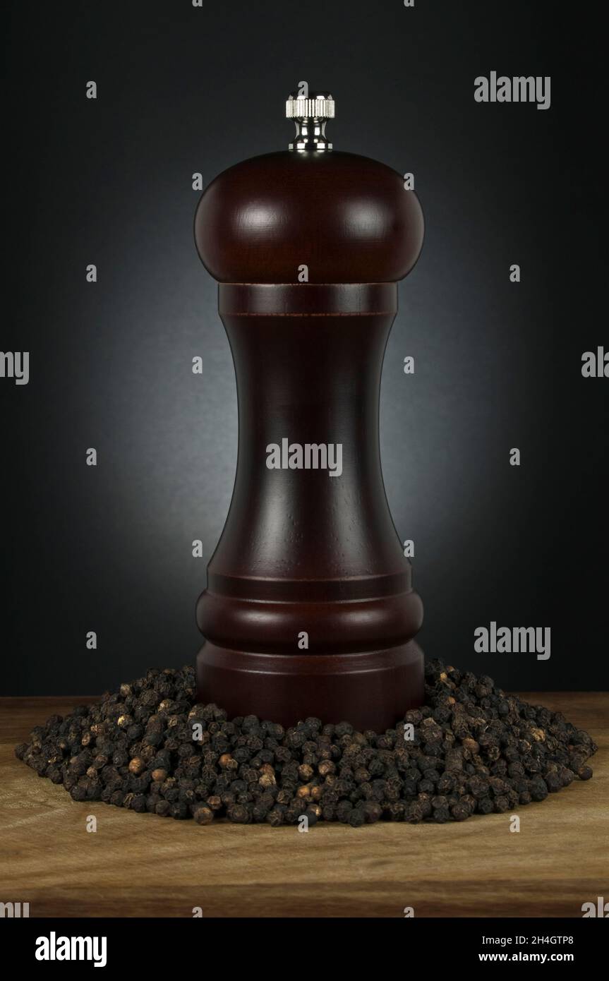 Timber Pepper Pepper grinder on timber bench with a pile of pepper corns, low key ...