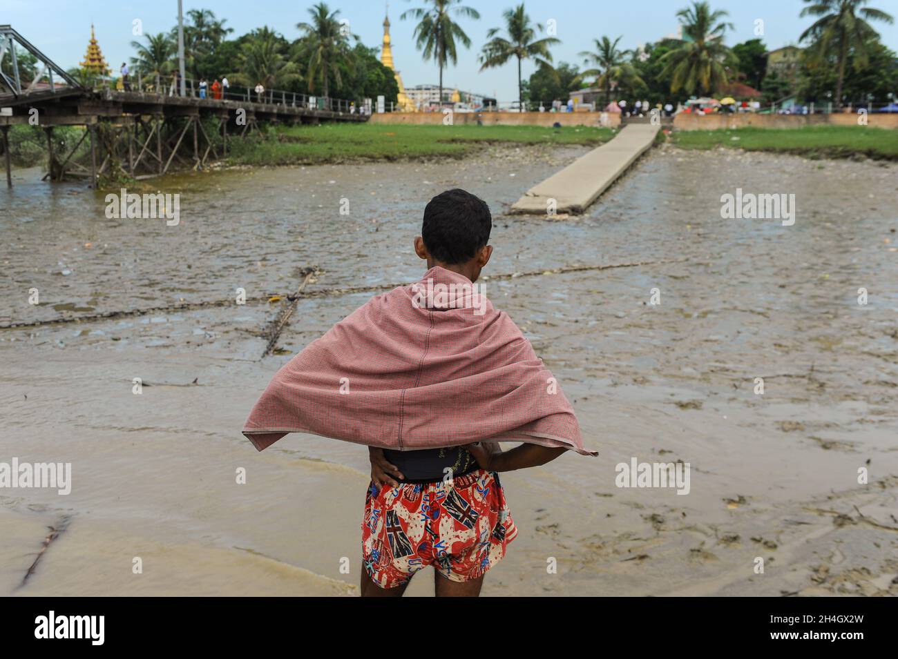11.11.2015, Yangon, Myanmar, Asia - A man is seen standing opposite the Botataung jetty at the waterfront by the Yangon River (Hlaing River). Stock Photo