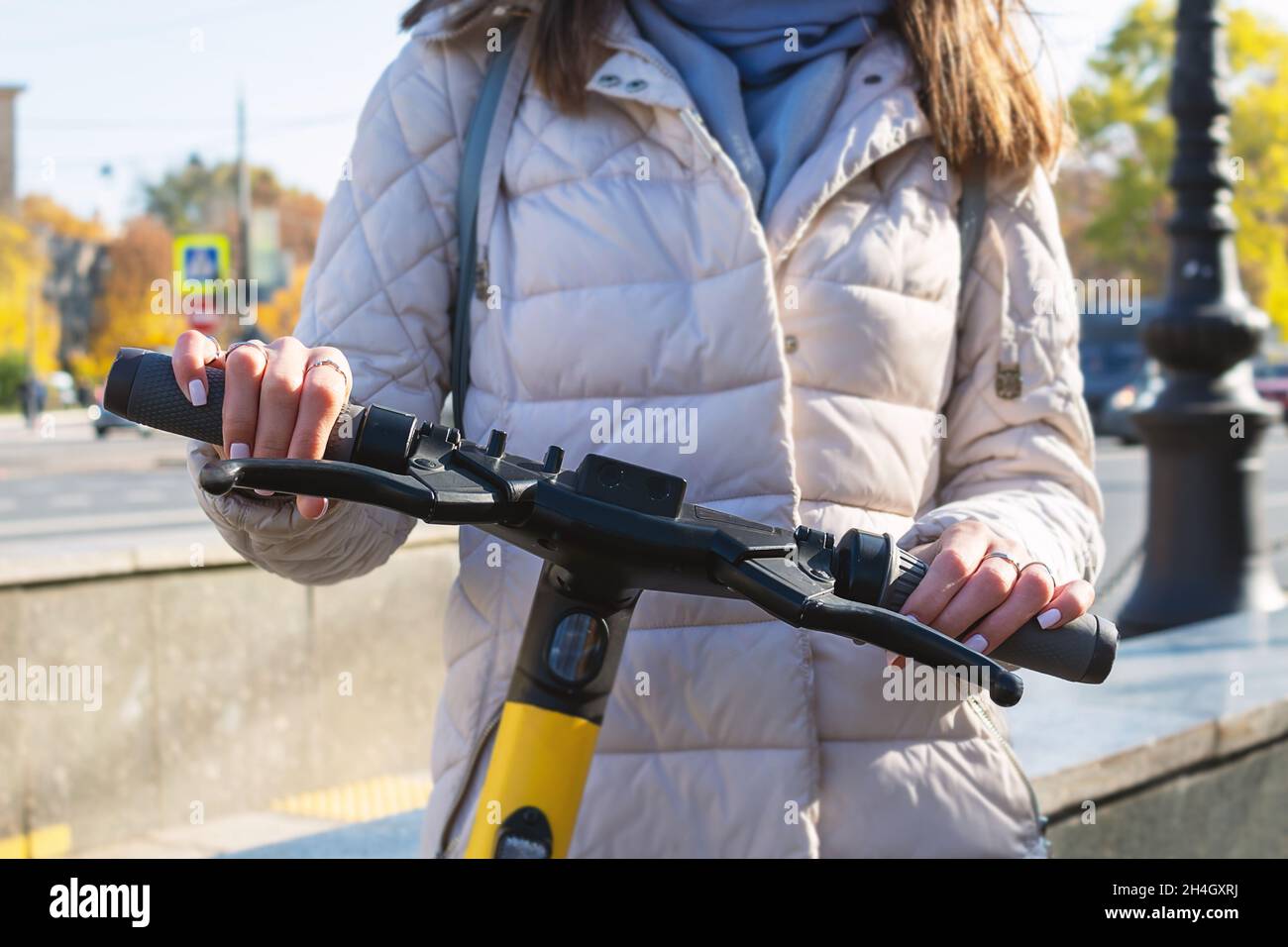 Woman on electric scooter in city. Close-up. Stock Photo