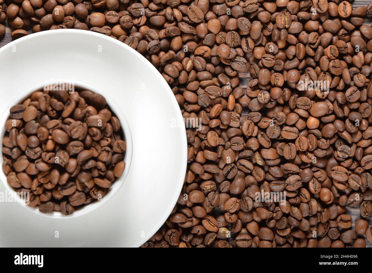 White coffee mug filled with coffee beans Stock Photo