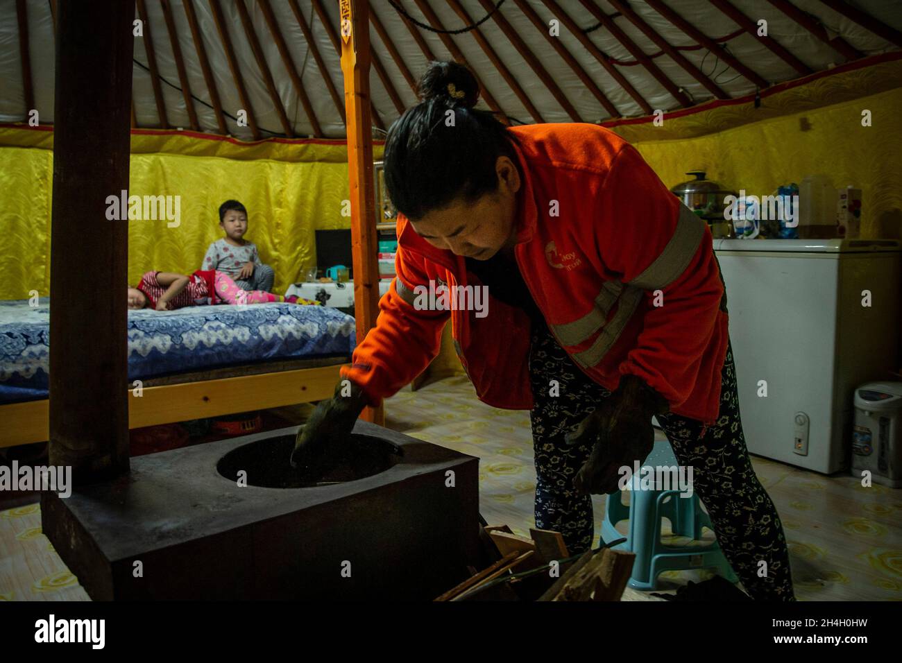 Pagmadulam, 33, stacks raw coal in the stove of her home as night approaches in a ger district of the capital Ulaanbaatar, January 19, 2019. The surro Stock Photo