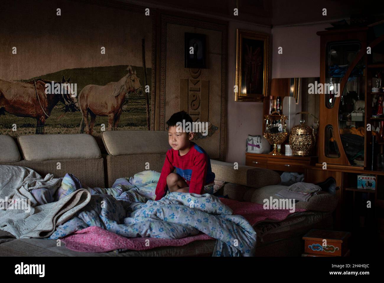 A boy wakes up in his grandparent's home in the countryside, about 100 kms from the capital Ulaanbaatar, January 17, 2019. Parents try to get their ch Stock Photo