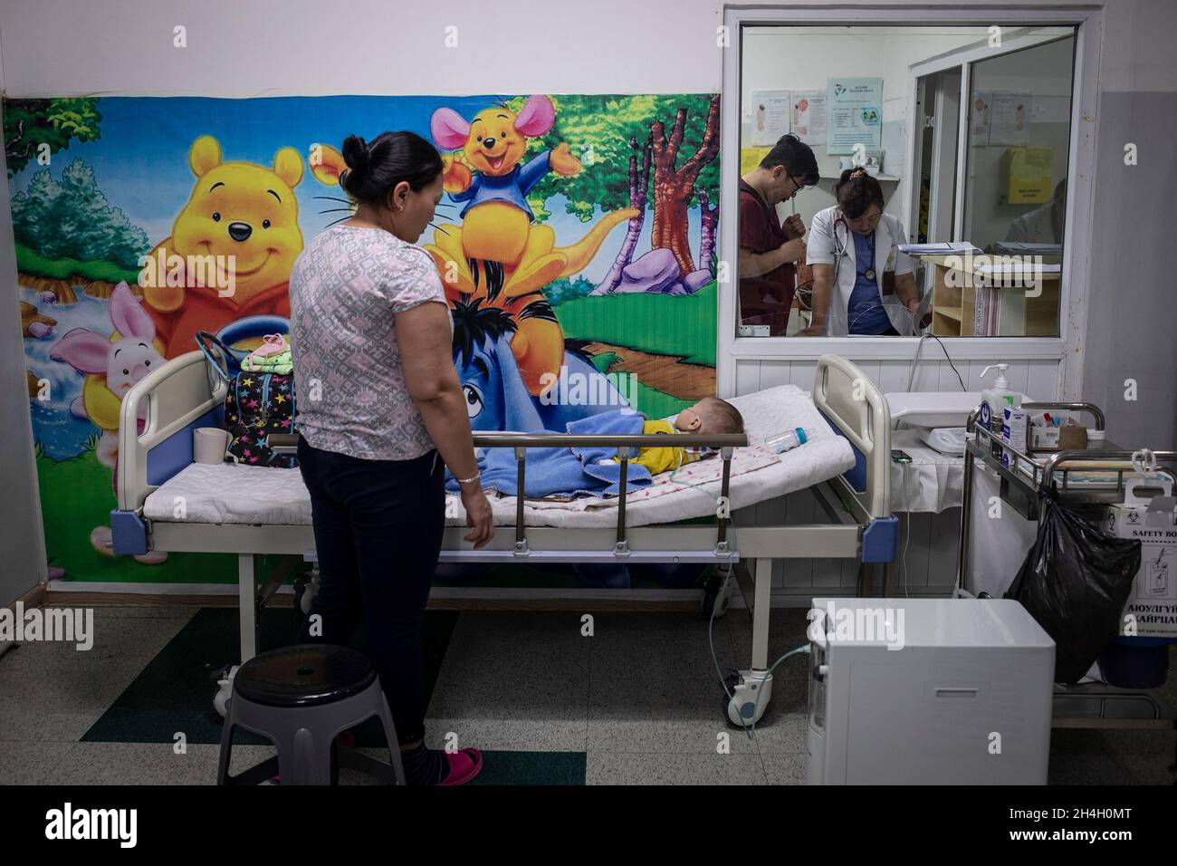A mother looks over her baby boy suffering from respiratory complications in a paediatric emergency unit in one of the  city hospitals in the capital Stock Photo