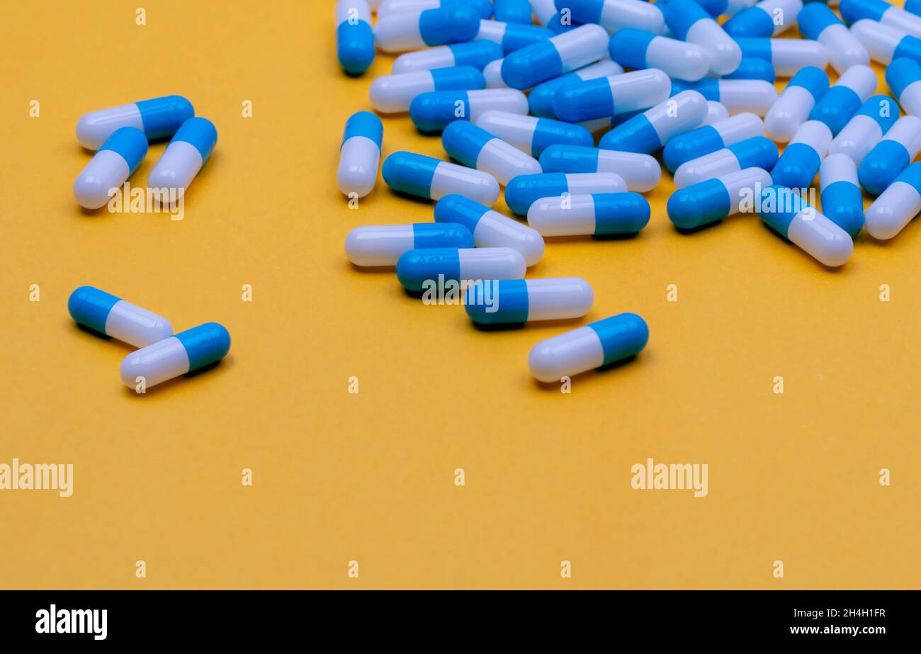Bluewhite capsule pills on yellow background. Online pharmacy banner. Group of capsule pills