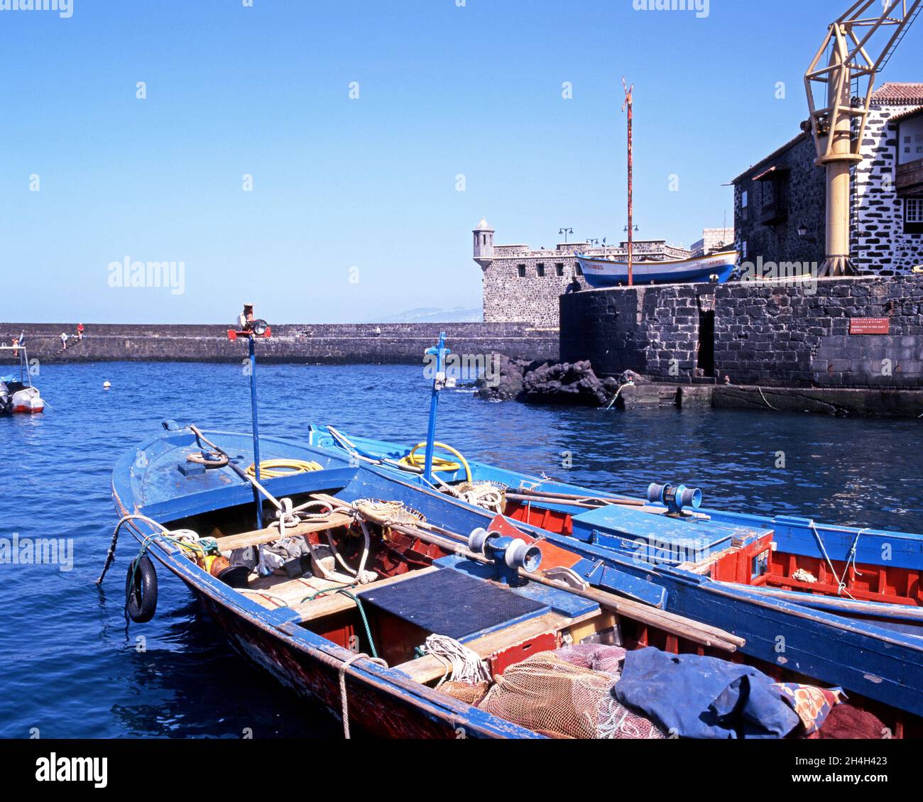 View of the harbour with fishing boats in the foreground, Puerto de la Cruz, Tenerife, Canary Islands, Spain. Stock Photo