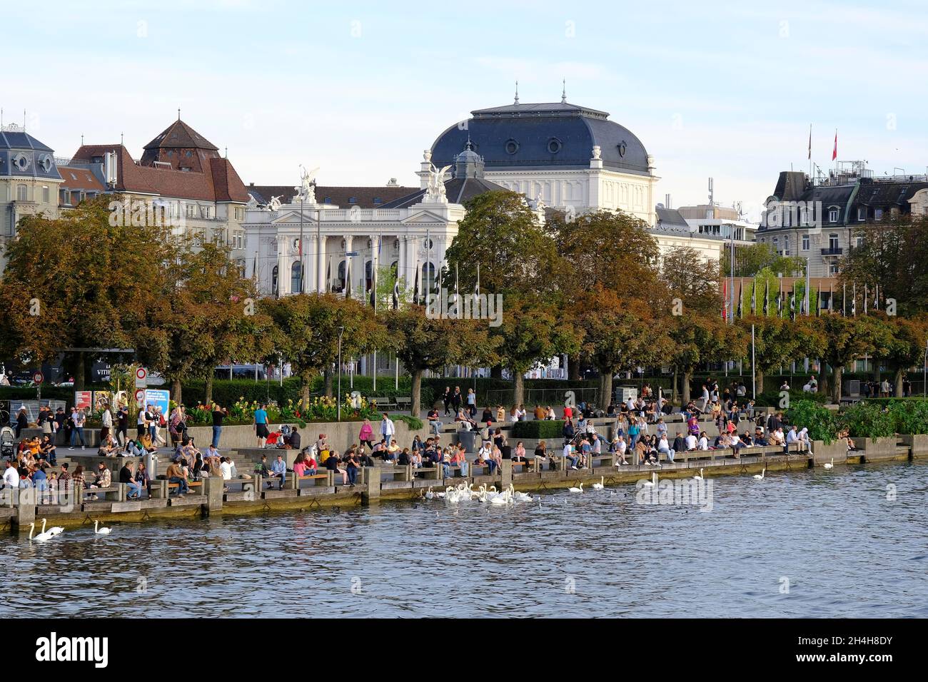 People sitting on quay, Opera House in the back, Zurich, Canton Zurich