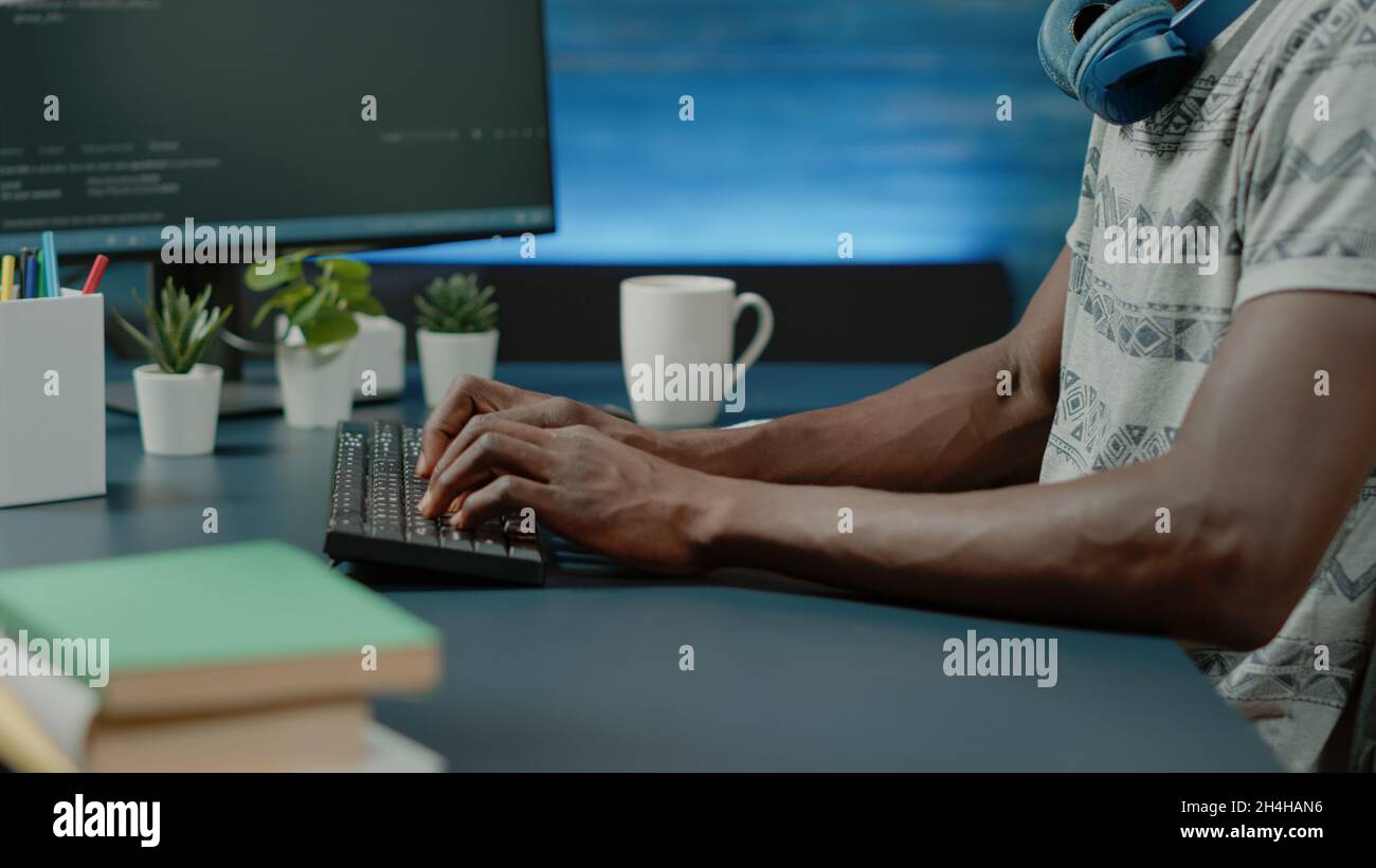 Close up of black hands coding server interface with binary codes on computer. African american coder programming website firewall for protection and software development. Web programmer Stock Photo