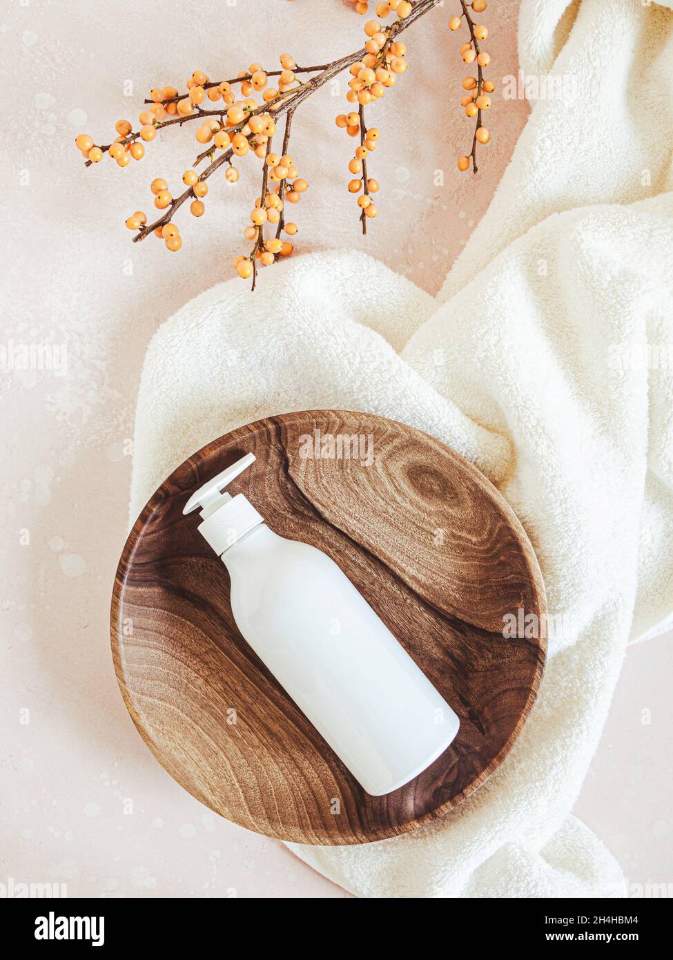 White plastic bottle with pump mock up, used for liquid soap, shampoo and lotion on wood tray on light background. Top view Stock Photo