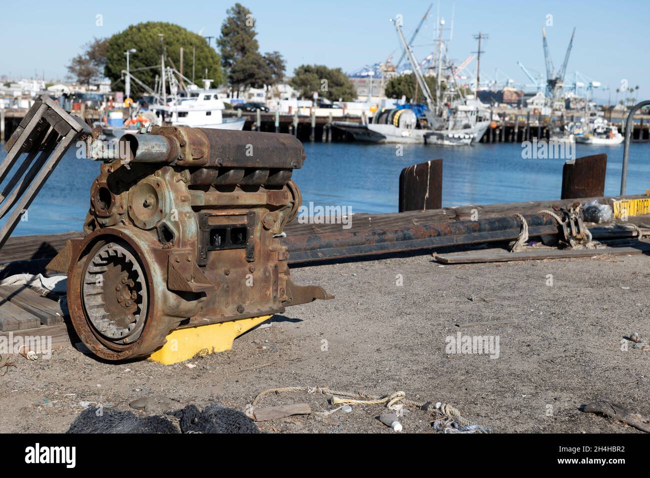 Rusty old boat engine at the dock in a commercial fishing harbor Stock