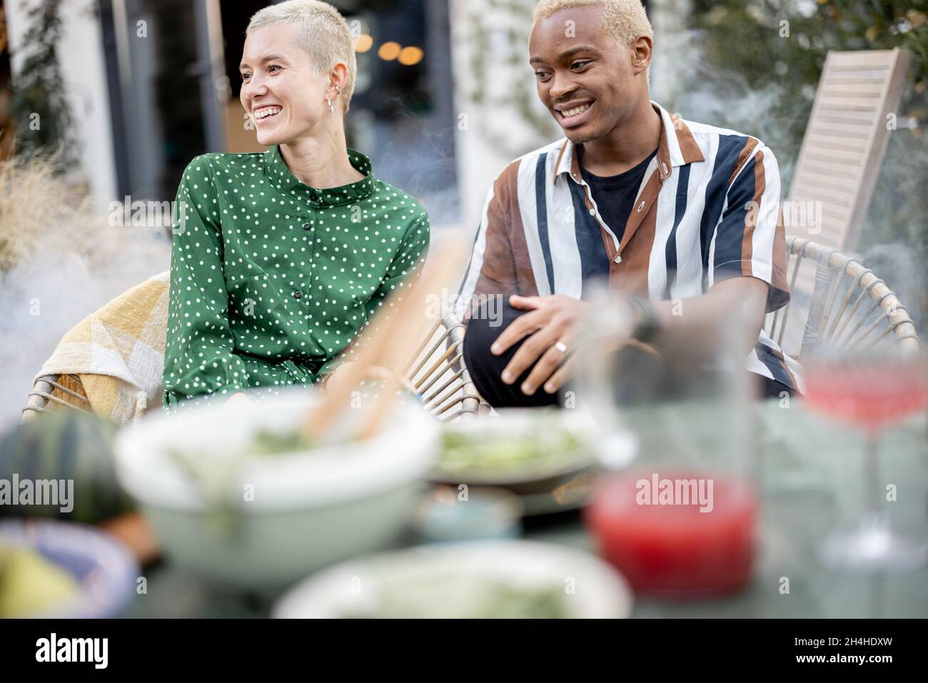 Multiracial couple having dinner at their backyard Stock Photo