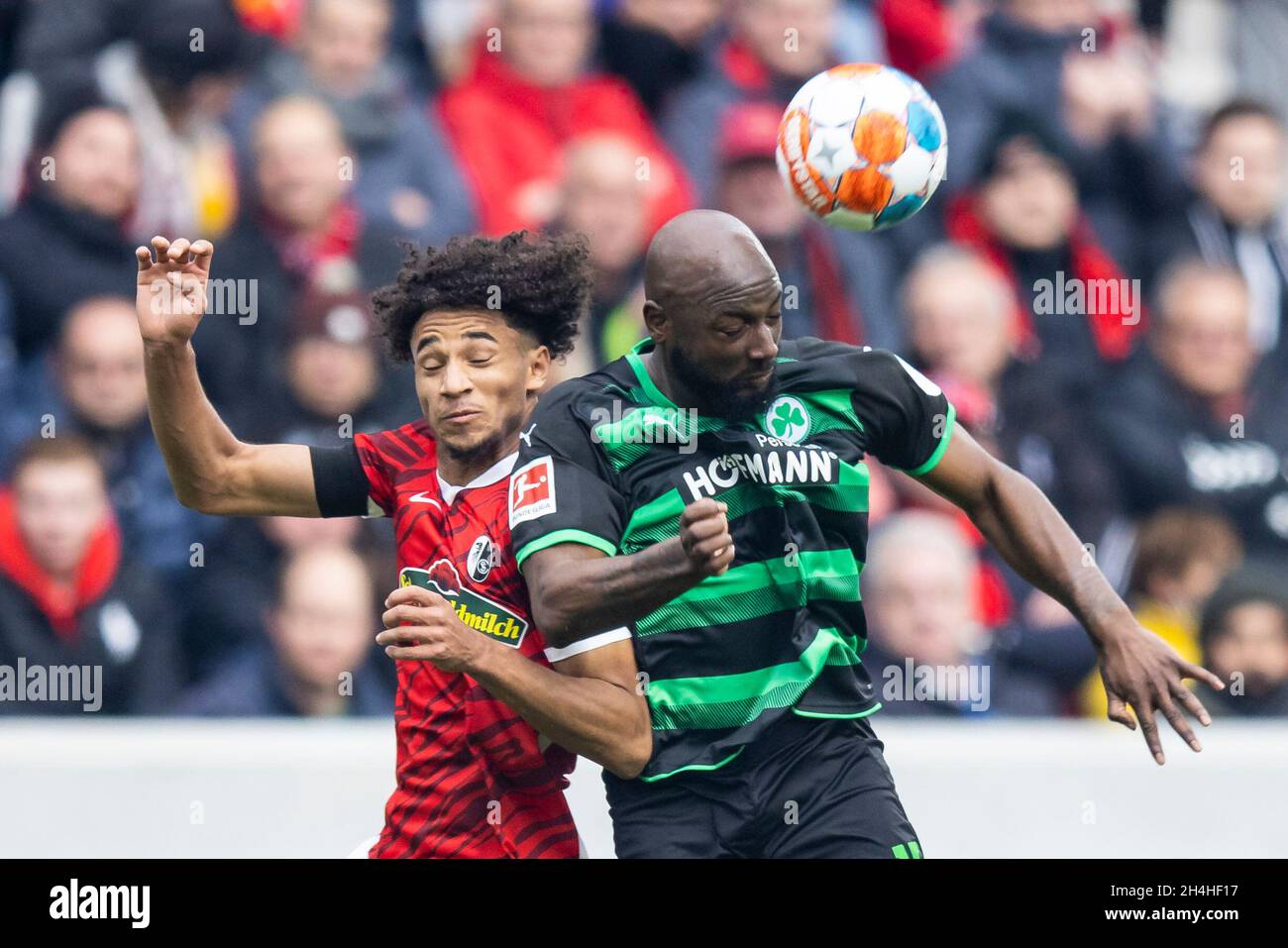 30 October 2021, Baden-Wuerttemberg, Freiburg im Breisgau: Football: Bundesliga, SC Freiburg - SpVgg Greuther Fürth, Matchday 10, Europa-Park Stadion. Freiburg's Kevin Schade (l) in action against Fürth's Jetro Willems (r). IMPORTANT NOTE: In accordance with the regulations of the DFL Deutsche Fußball Liga and the DFB Deutscher Fußball-Bund, it is prohibited to use or have used photographs taken in the stadium and/or of the match in the form of sequence pictures and/or video-like photo series. Photo: Tom Weller/dpa - IMPORTANT NOTE: In accordance with the regulations of the DFL Deutsche Fußbal Stock Photo