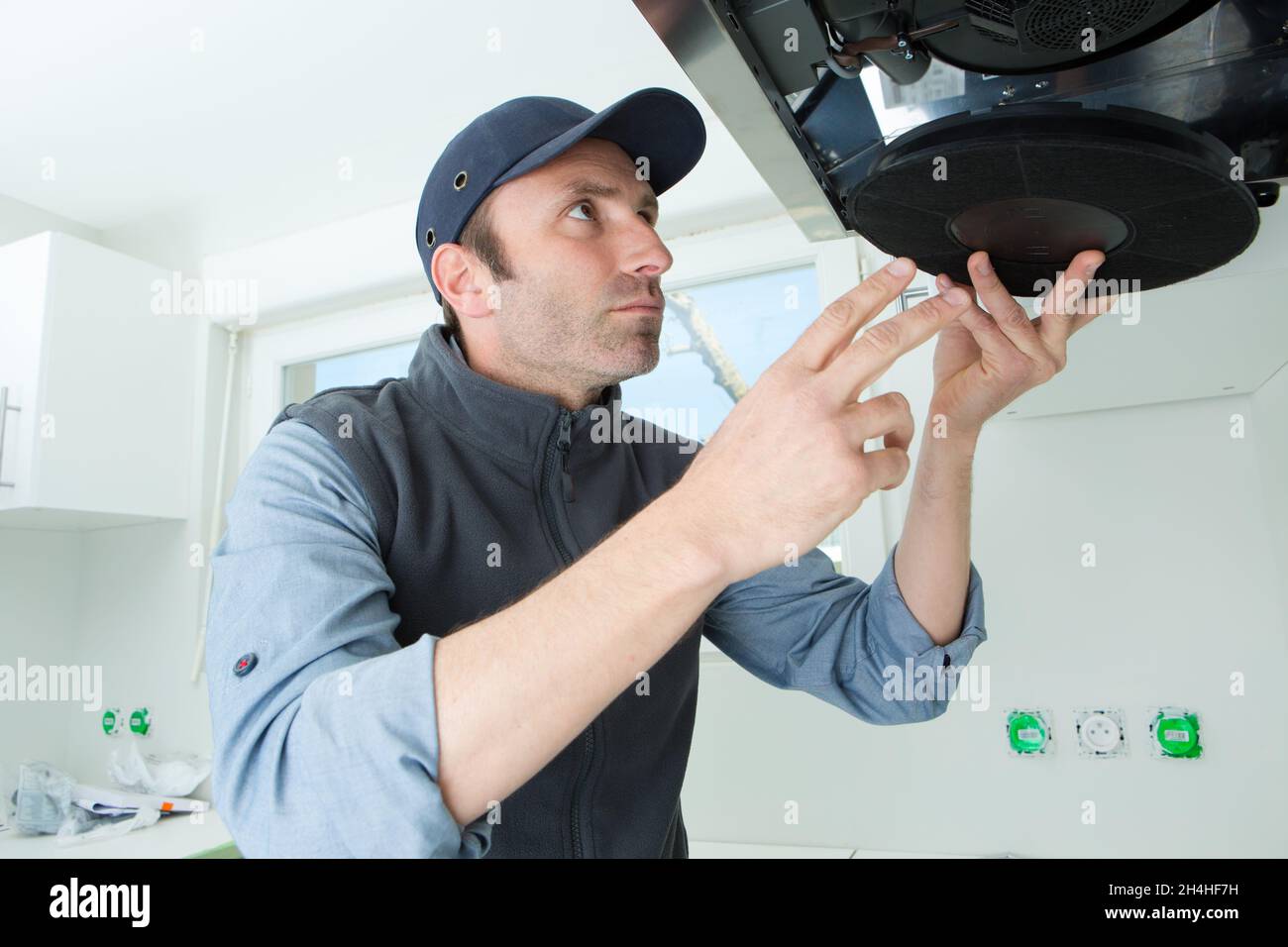 handyman repairing a kitchen extractor filter Stock Photo Alamy