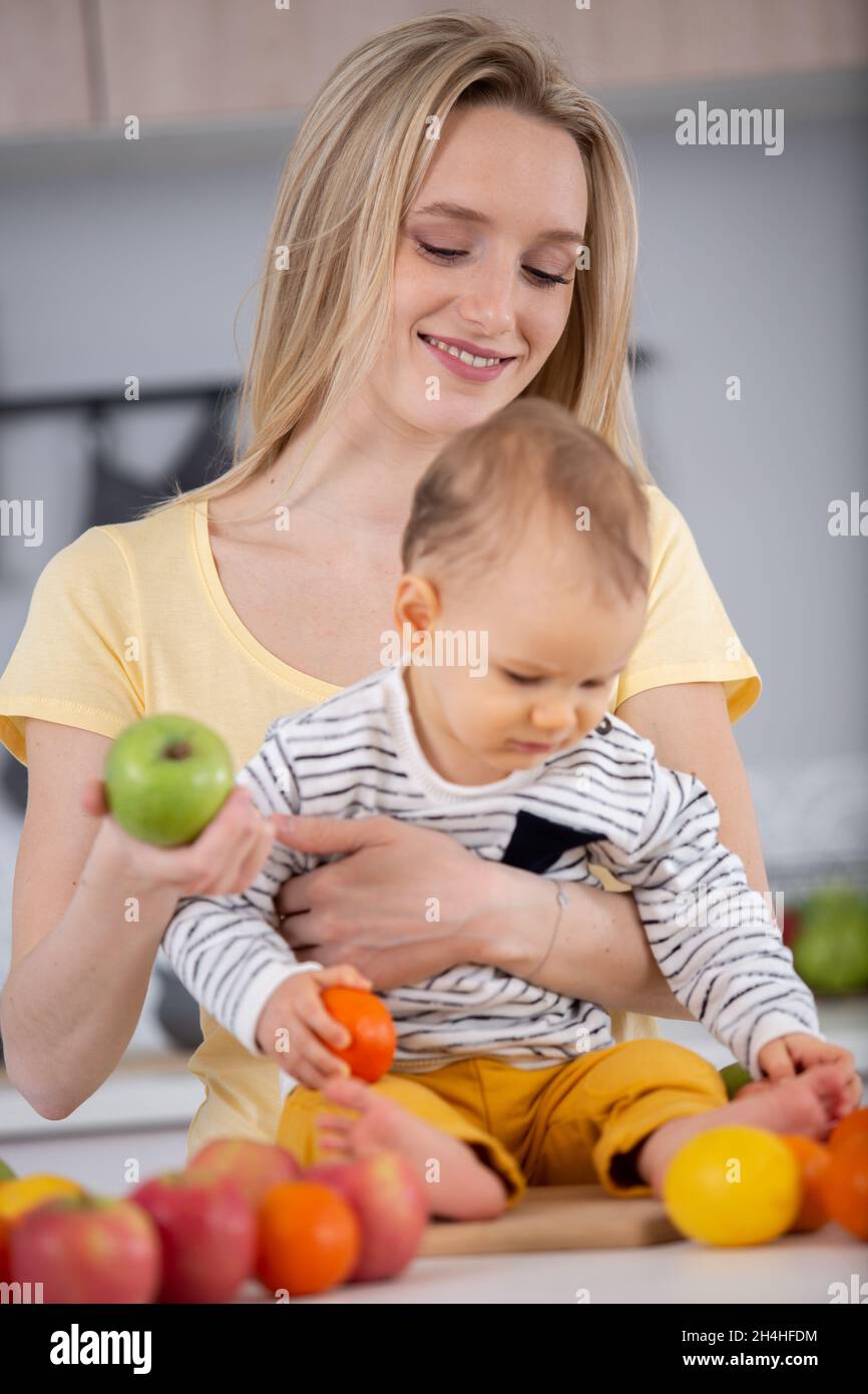 mother with her baby eating fruits Stock Photo Alamy