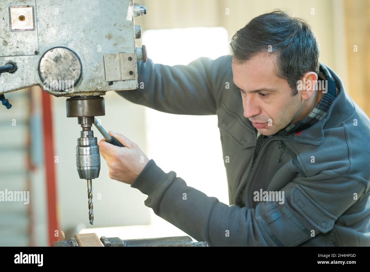 a workman using bench drill Stock Photo Alamy