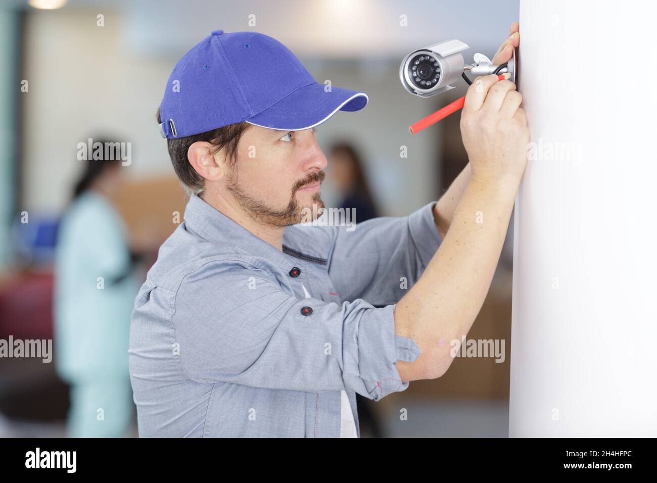 contractor installing a discreet security camera in a hospital Stock
