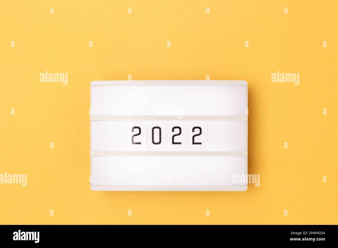White lightbox with 2022 numbers on a golden background with copy space. Stock Photo