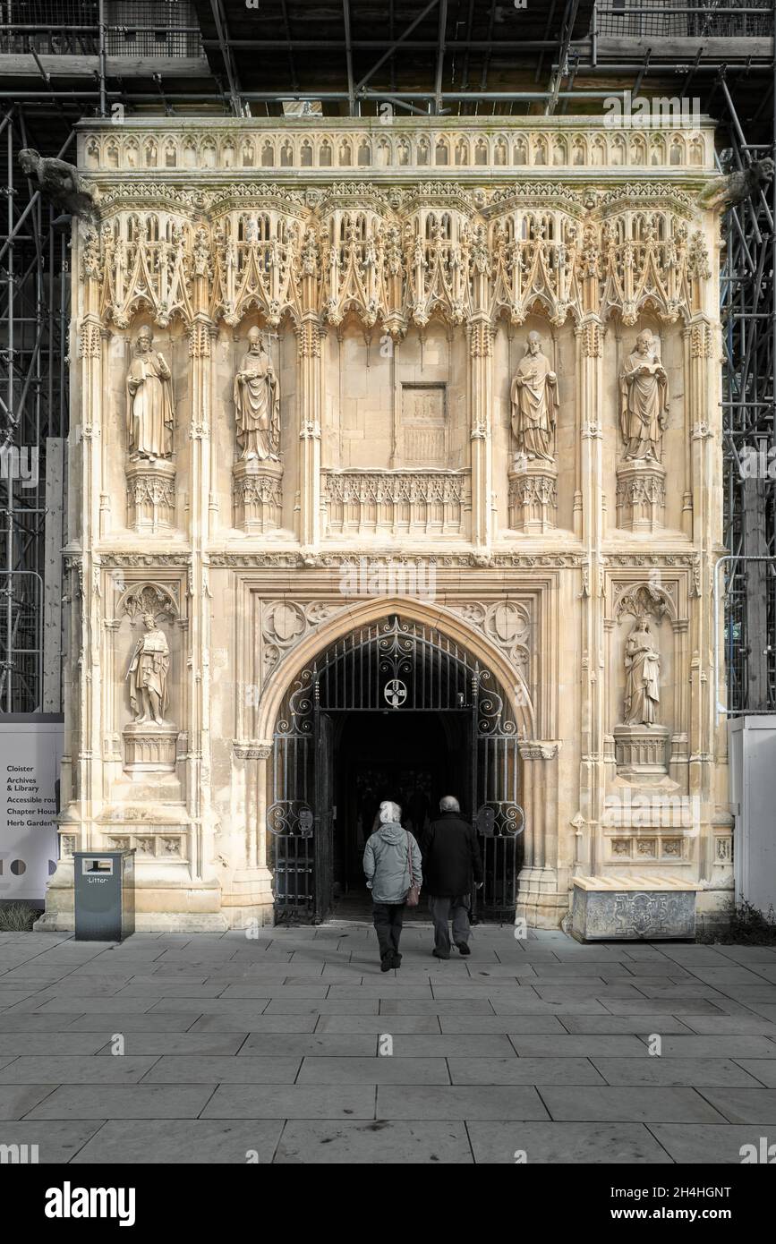 Two visitors enter the cathedral of Canterbury, England, by the decorated south-west entrance. Stock Photo