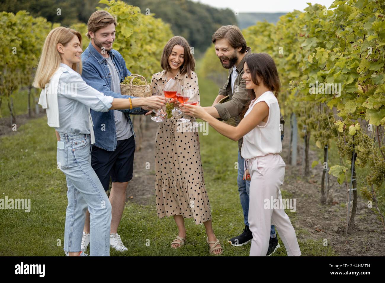 Friends tasting wine near vineyards in countryside Stock Photo