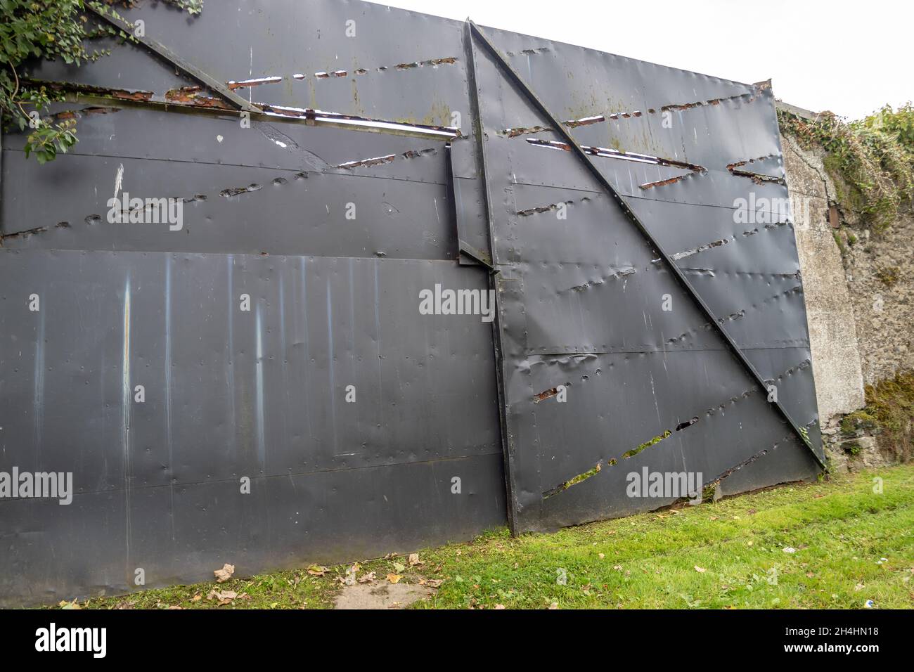 Old wobbly black metal gate with holes Stock Photo - Alamy