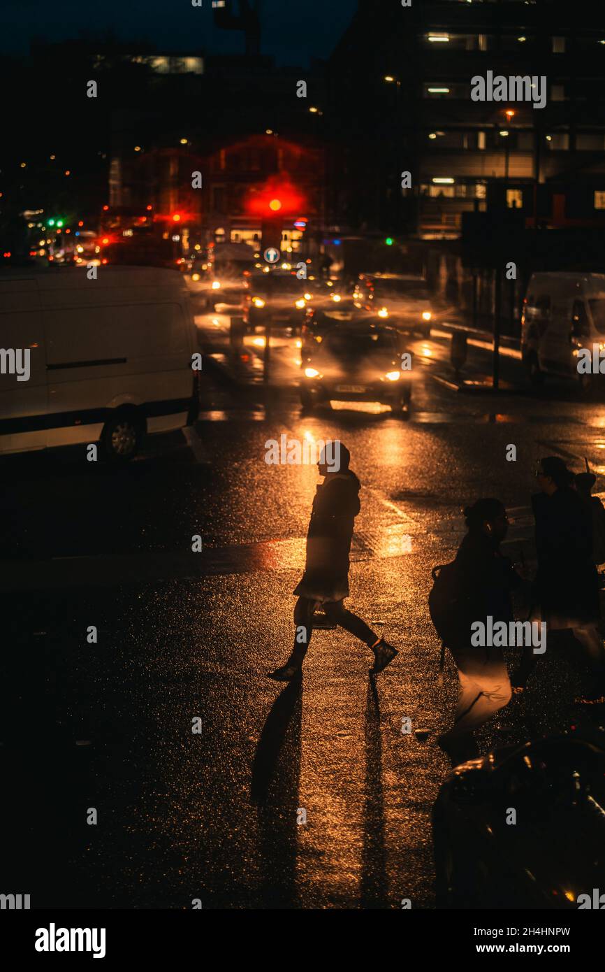 London, UK. 06th Jan, 2021. Frau läuft, im Scheinwerfer Licht eines Autos, über eine Straße in London im Winter. * Woman walking, in headlights light of a car, across a street in London in winter. (Photo by Alexander Pohl/Sipa USA) Credit: Sipa USA/Alamy Live News Stock Photo