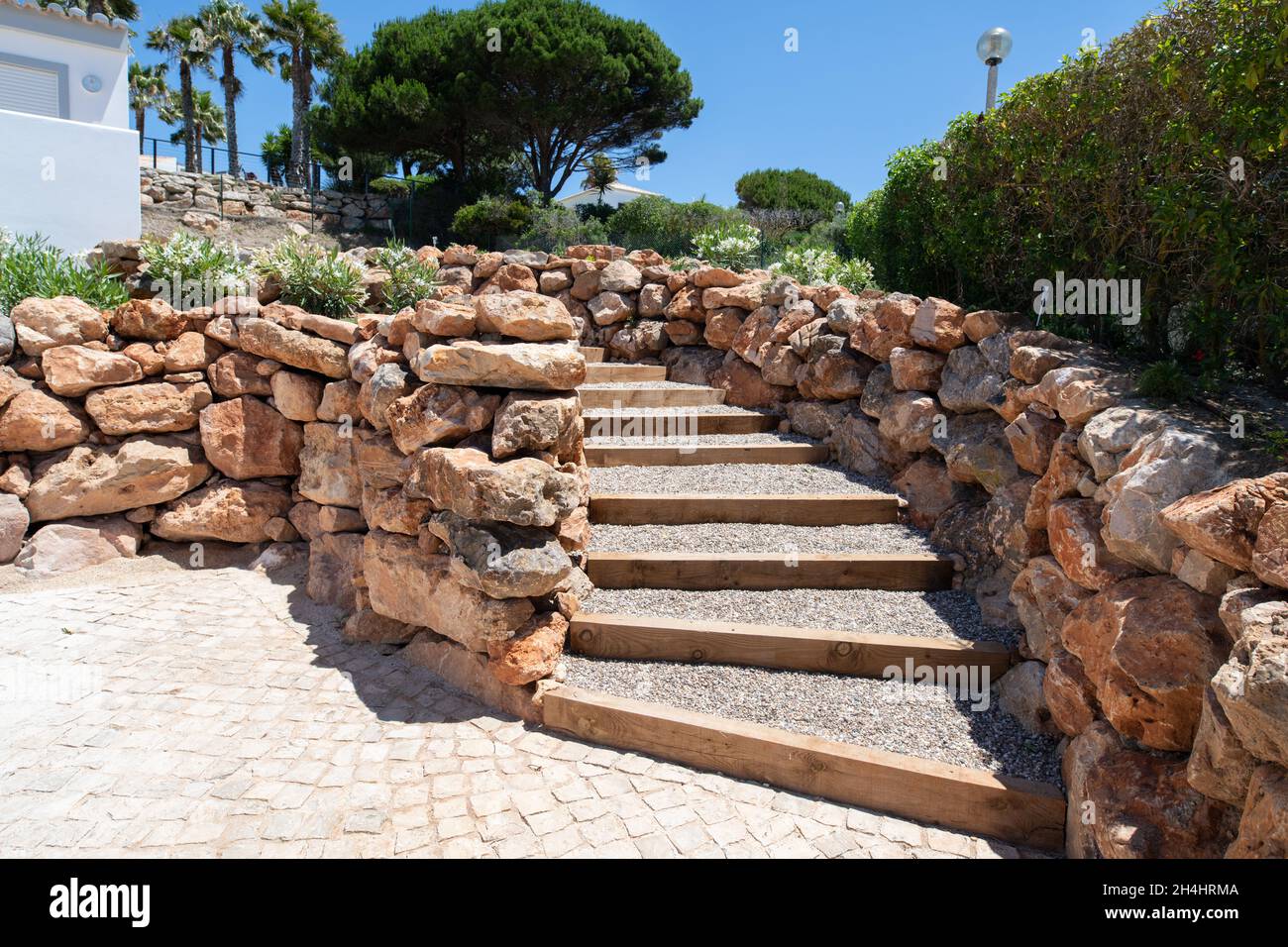 Outside steps filled with gravel and surrounded by large stone walls Stock Photo