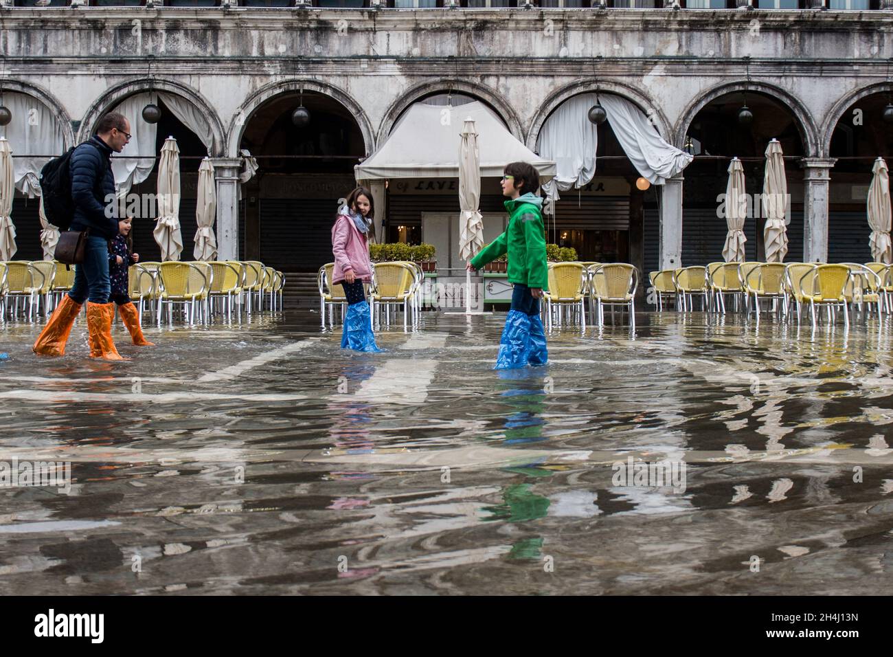 Venice, Italy. 03rd November, 2021. Tourists walk in a flooded St. Mark square during an high tide on November 3, 2021 in Venice, Italy. In these days Venice is under water due to the high level of the tide for climate change, and Mose is activated, but not sufficient. © Simone Padovani / Awakening / Alamy Live News Stock Photo