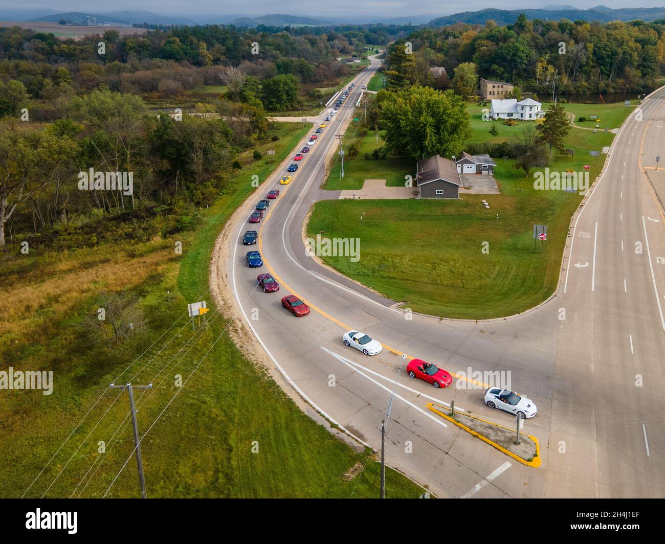 Route with a row of cars surrounded by houses and trees in La Crosse