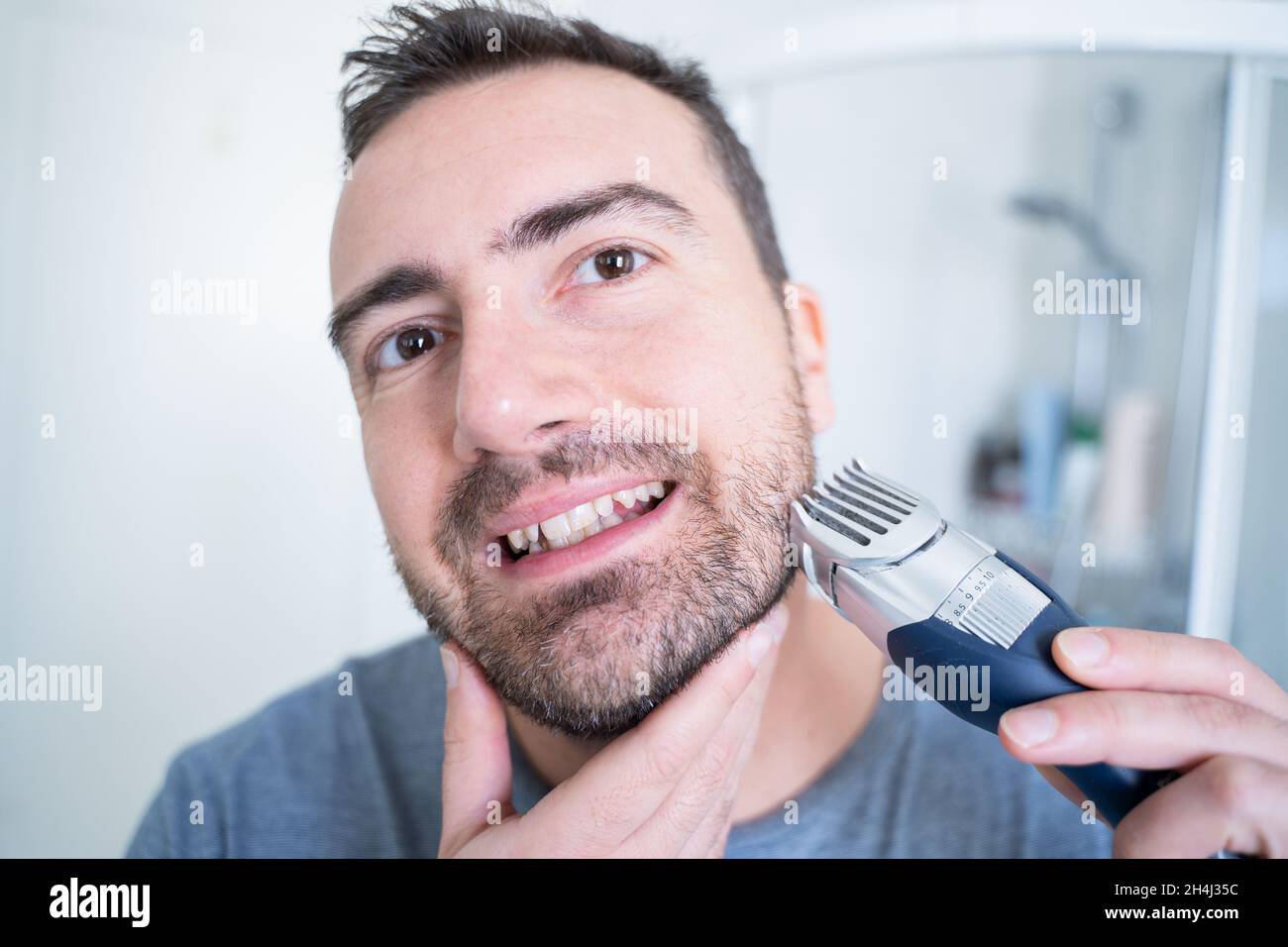 Man trimming his beard using electric beard trimmer Stock Photo Alamy