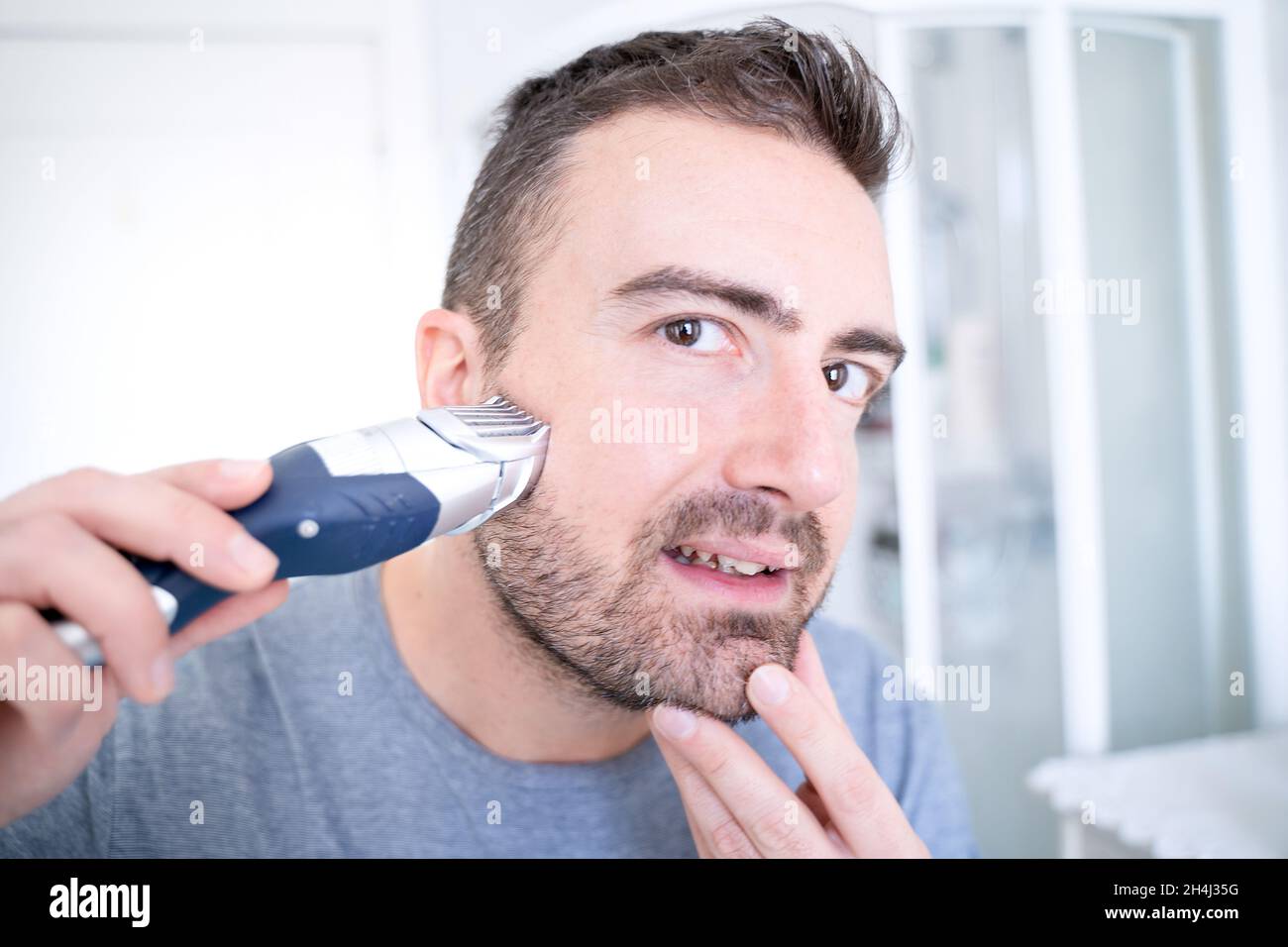 Man trimming his beard using electric beard trimmer Stock Photo Alamy