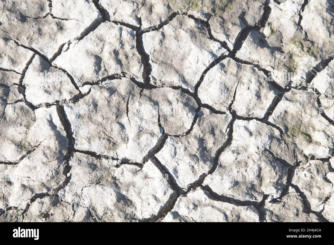 Dried out earth with deep cracks due to the drought gives a close up pattern Stock Photo