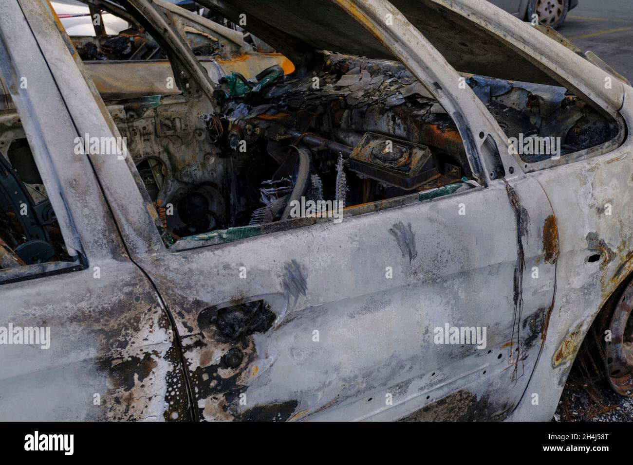 Burnt car's door in the street close-up. Riot, civil protest, hooliganism, criminal in the city. Exp Stock Photo