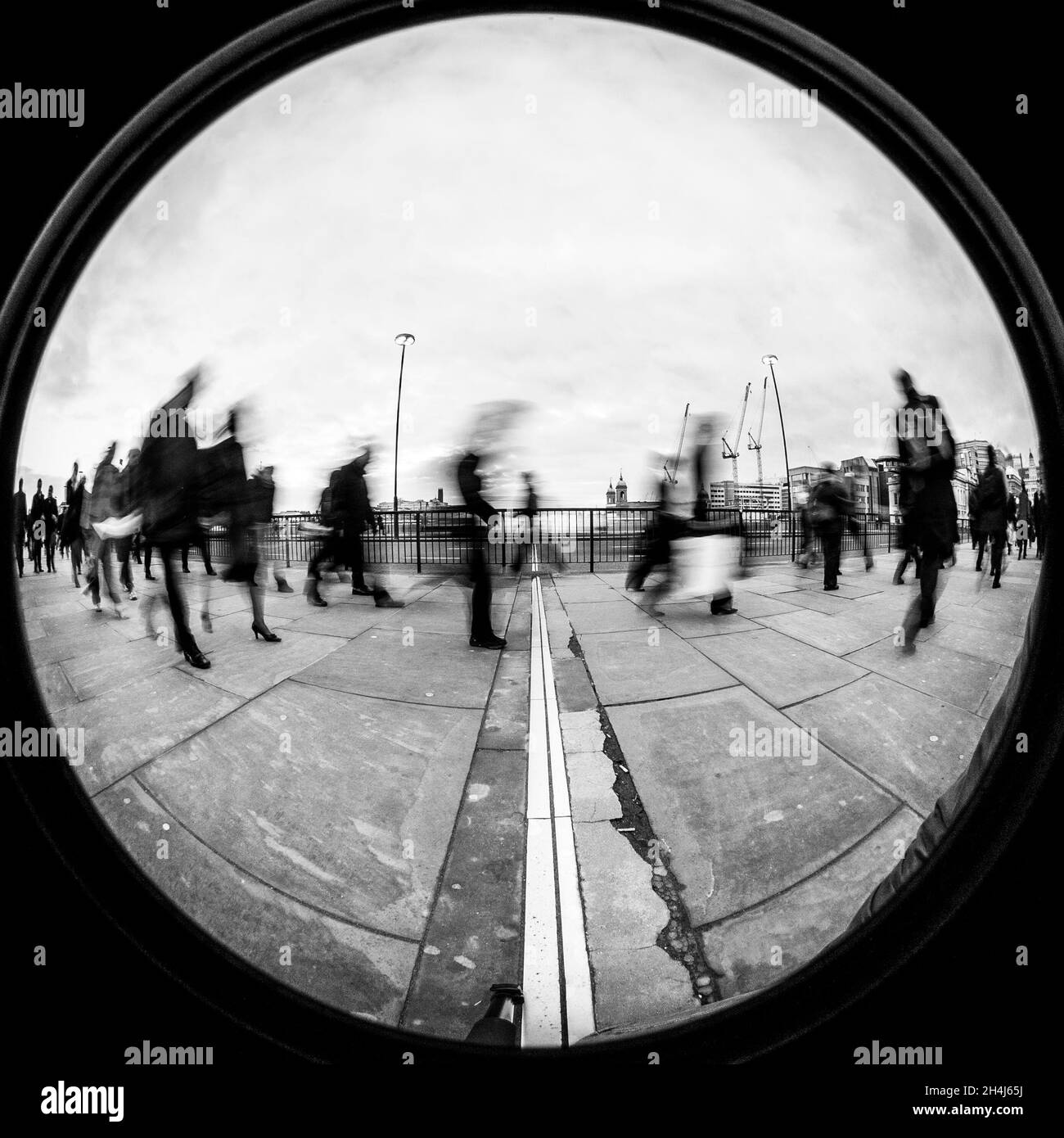 London Commuters. Creative long exposure high contrast abstract view of office workers walking to work. 180 degree wide angle fish eye. Stock Photo