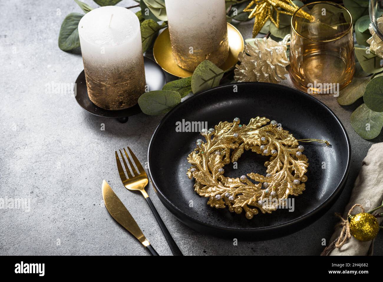 Christmas table setting with eucalyptus leaves and golden decorations ...