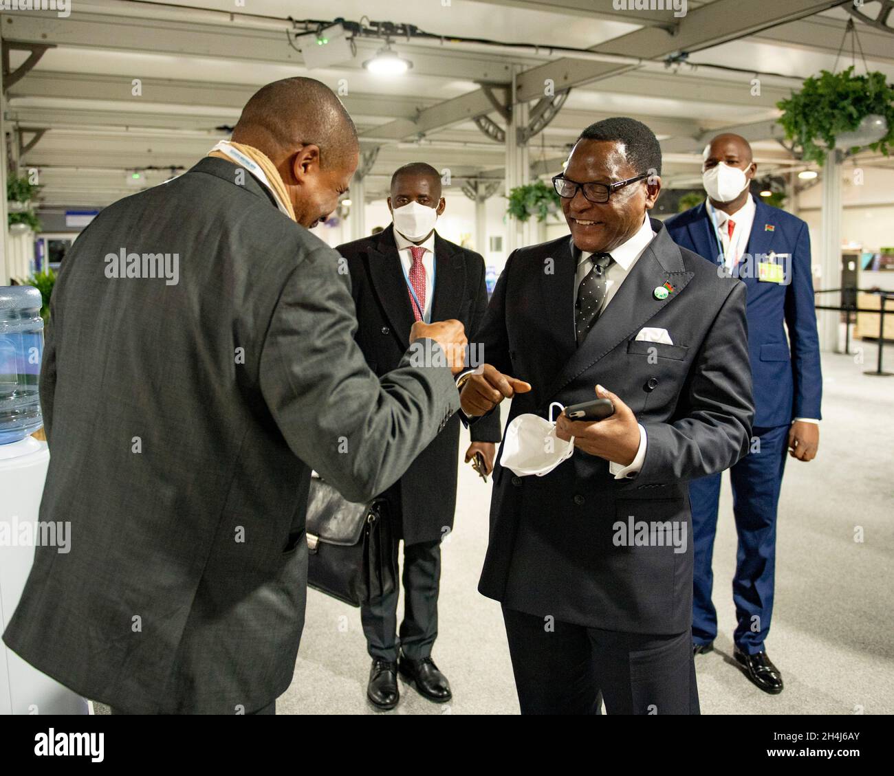 Glasgow, Scotland, UK. 2 November 2021 PICTURED: (right) President Lazarus Chakwera, President of Malawi seen at COP26 fist pumping a delegate. The president of the Republic of Malawi (Chichewa: Mtsogoleri wa Dziko la Malawi) is the head of state and head of government of Malawi. The president leads the executive branch of the Government of Malawi and is the commander-in-chief of the Malawian Defence Force. The current president is Lazarus Chakwera, who defeated Peter Mutharika in the 2020 rerun presidential election. Chakwera was sworn in as president of Malawi on 28 June. Credit: Colin Fishe Stock Photo