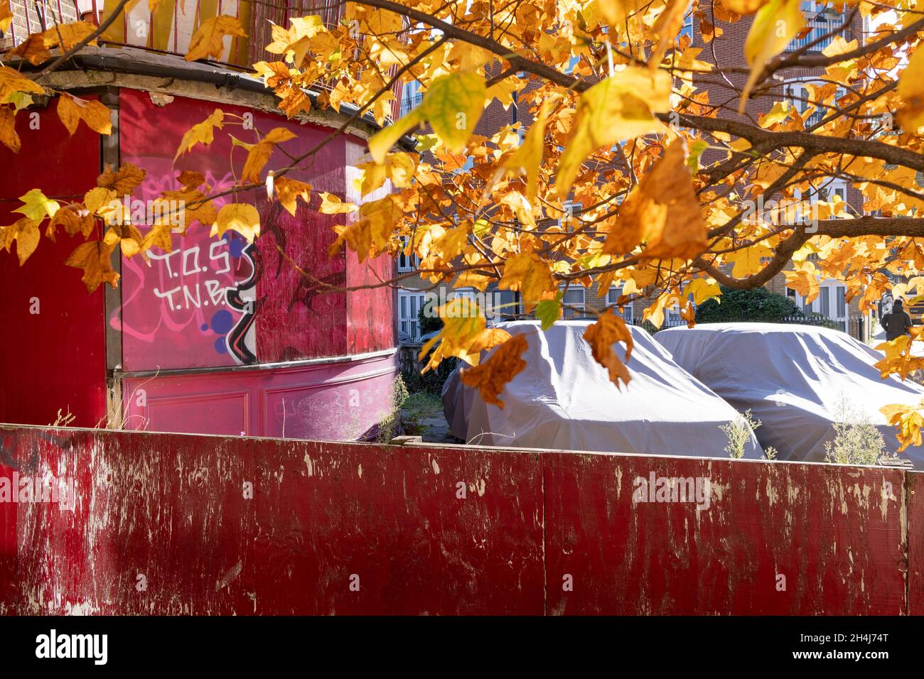 Two stored cars are parked under shiny covers on private property, a derelict Whitechapel pub in the East End, on 2nd November 2021, in London, England. Stock Photo