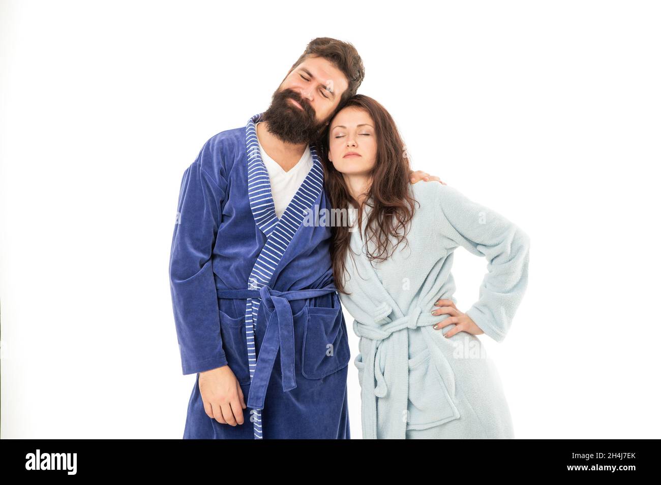 Tired couple of man and woman stand sleeping in cozy robes isolated on