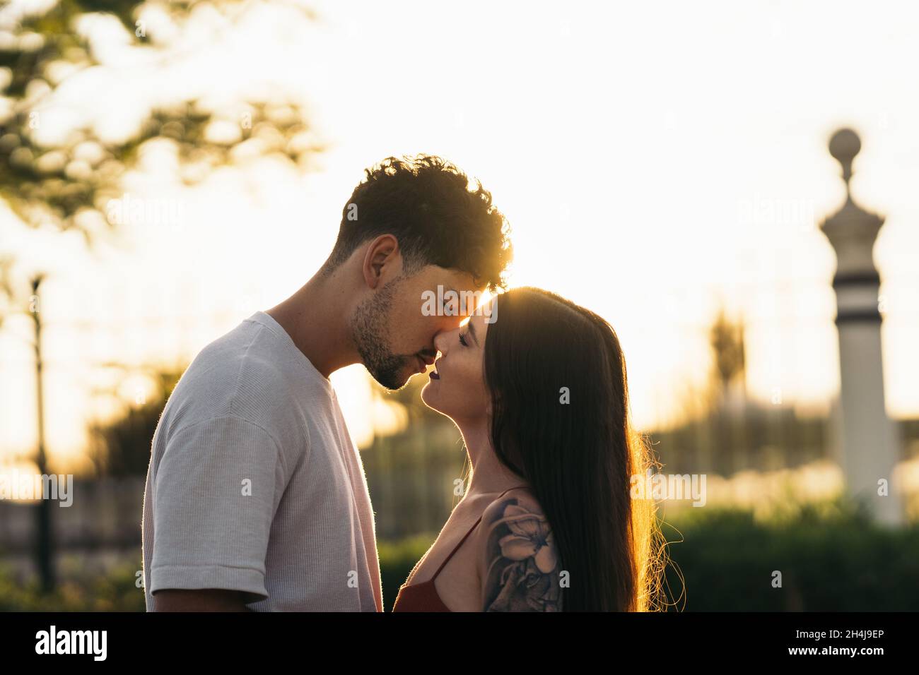 Young couple kissing during sunset Stock Photo - Alamy