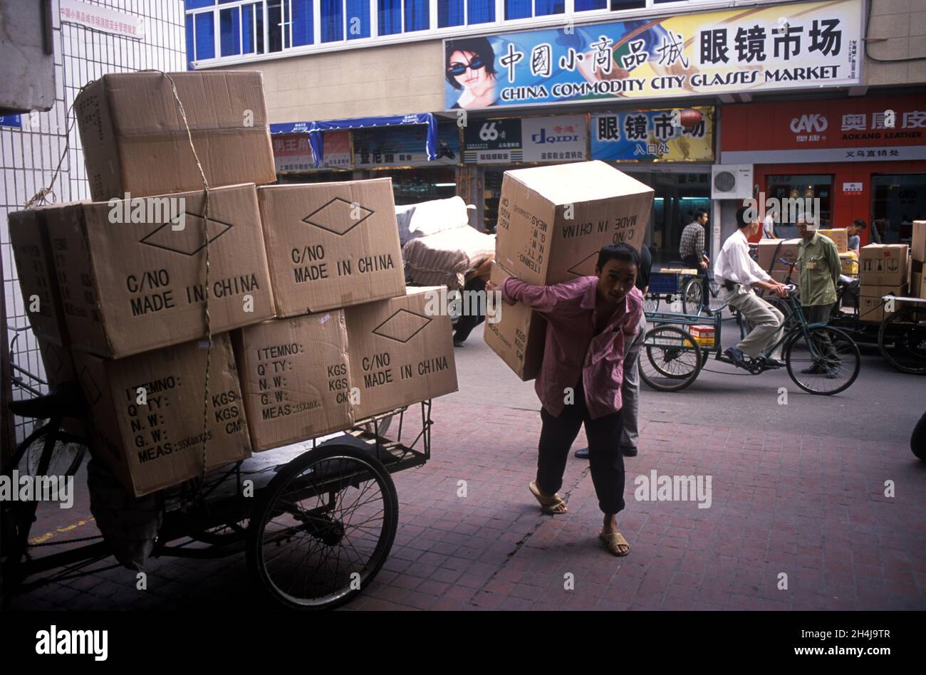 Yiwu, Zhejiang Province,  Republic of China, 2001, 2000s,  Consumer goods destined for the English-speaking world. Made in China is printed on large brown boxes carried off by a market trader in the small commodities Yiwu market which is the largest market in the world with an annual turn over of over $1billion. HOMER SYKES Stock Photo