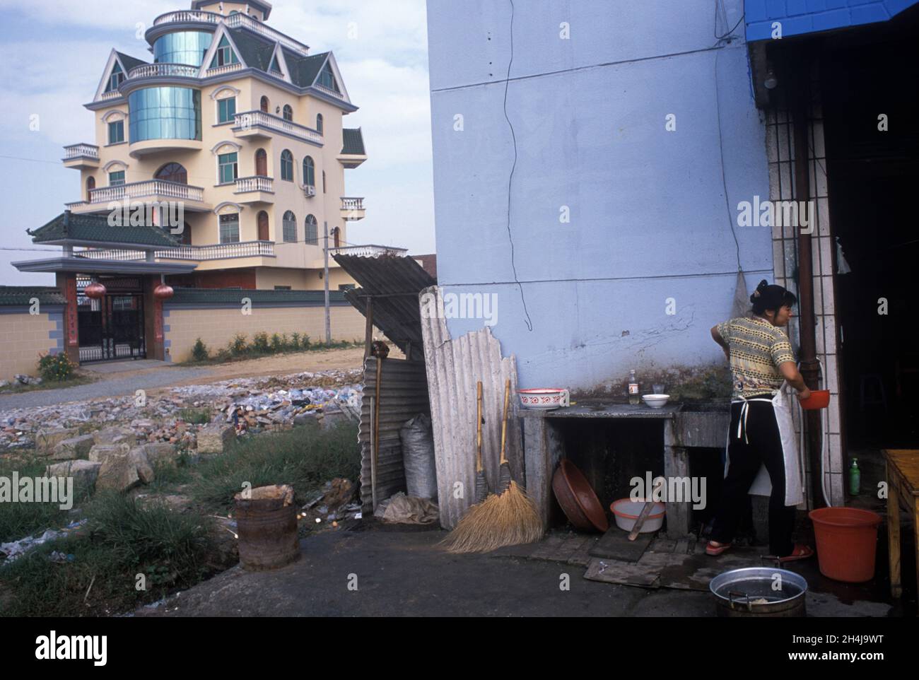 China 2000s, wealth poverty income disparity, Huge modern new trophy house and small local cafe across the road. Chinese new money  Yiwu, Zhejiang Province. 2001, 2000s.  HOMER SYKES Stock Photo