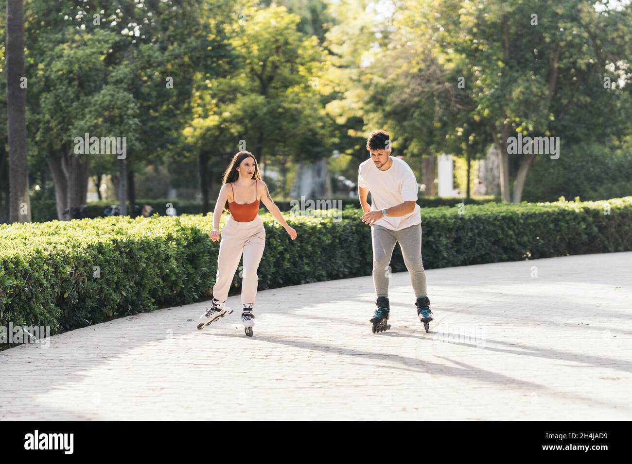 Young people skating with inline skates in a paved surface of a park