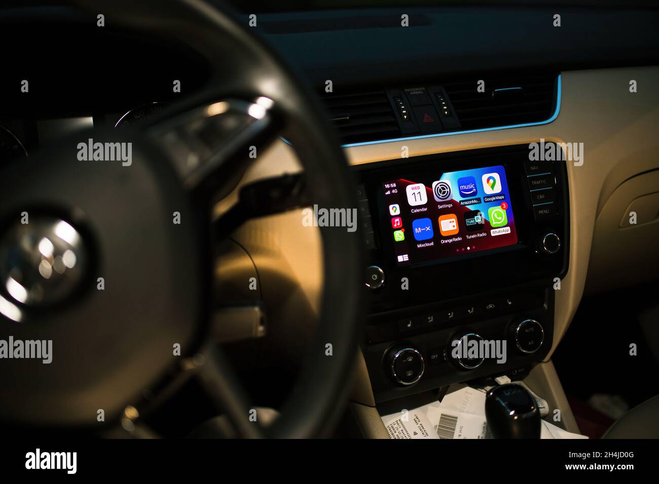 Luxury car interior at night with dashboard computer showing on display Apple CarPlay Stock Photo