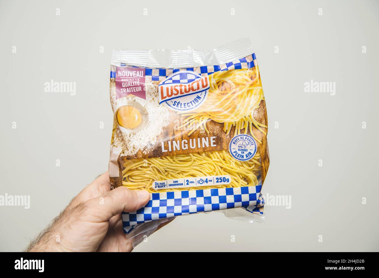 POV male hand holding package of Lustrucru selection Linguine pasta
